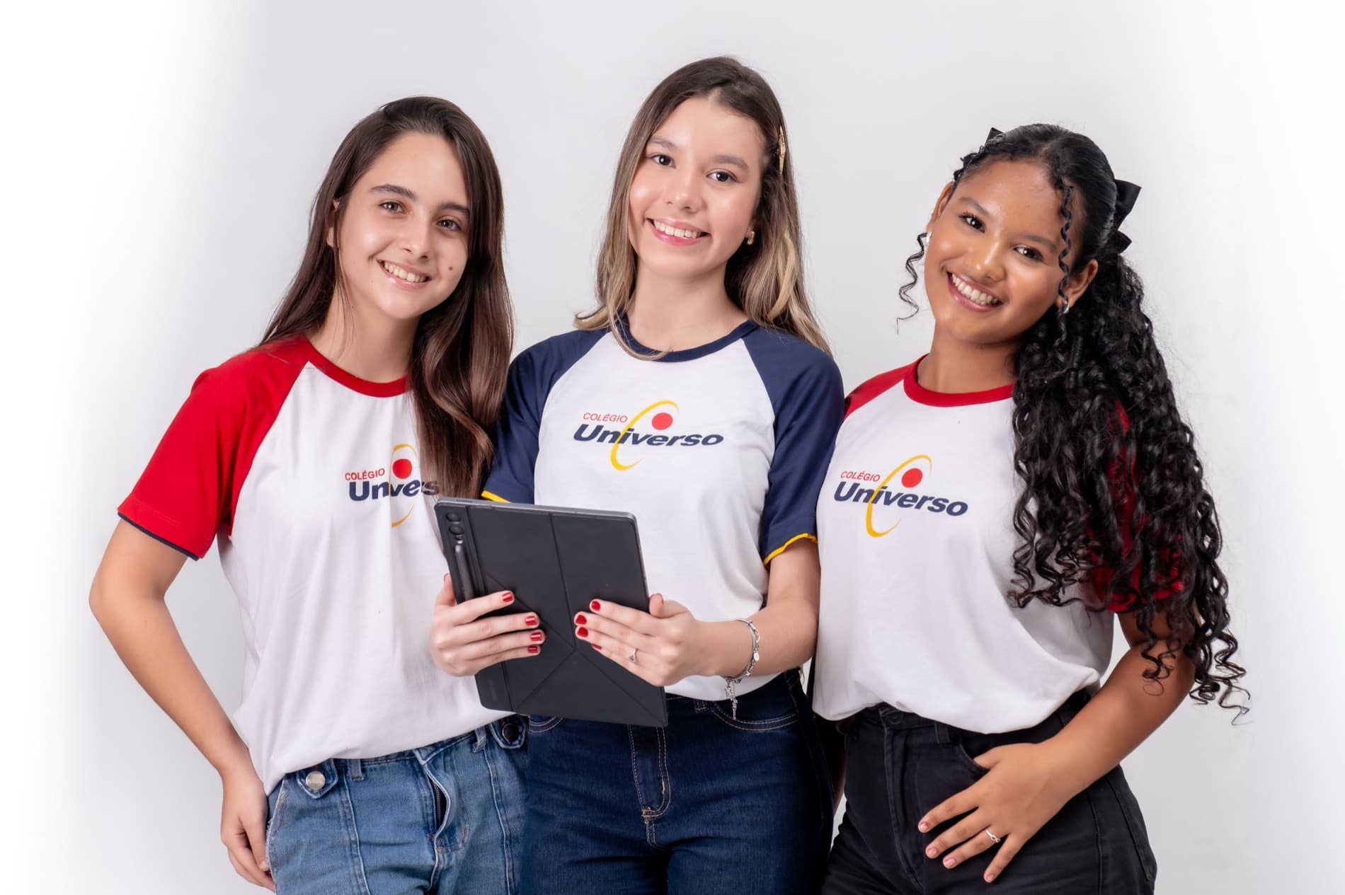 Estudantes do Colégio Universo estudando juntas com apostilas e tablet