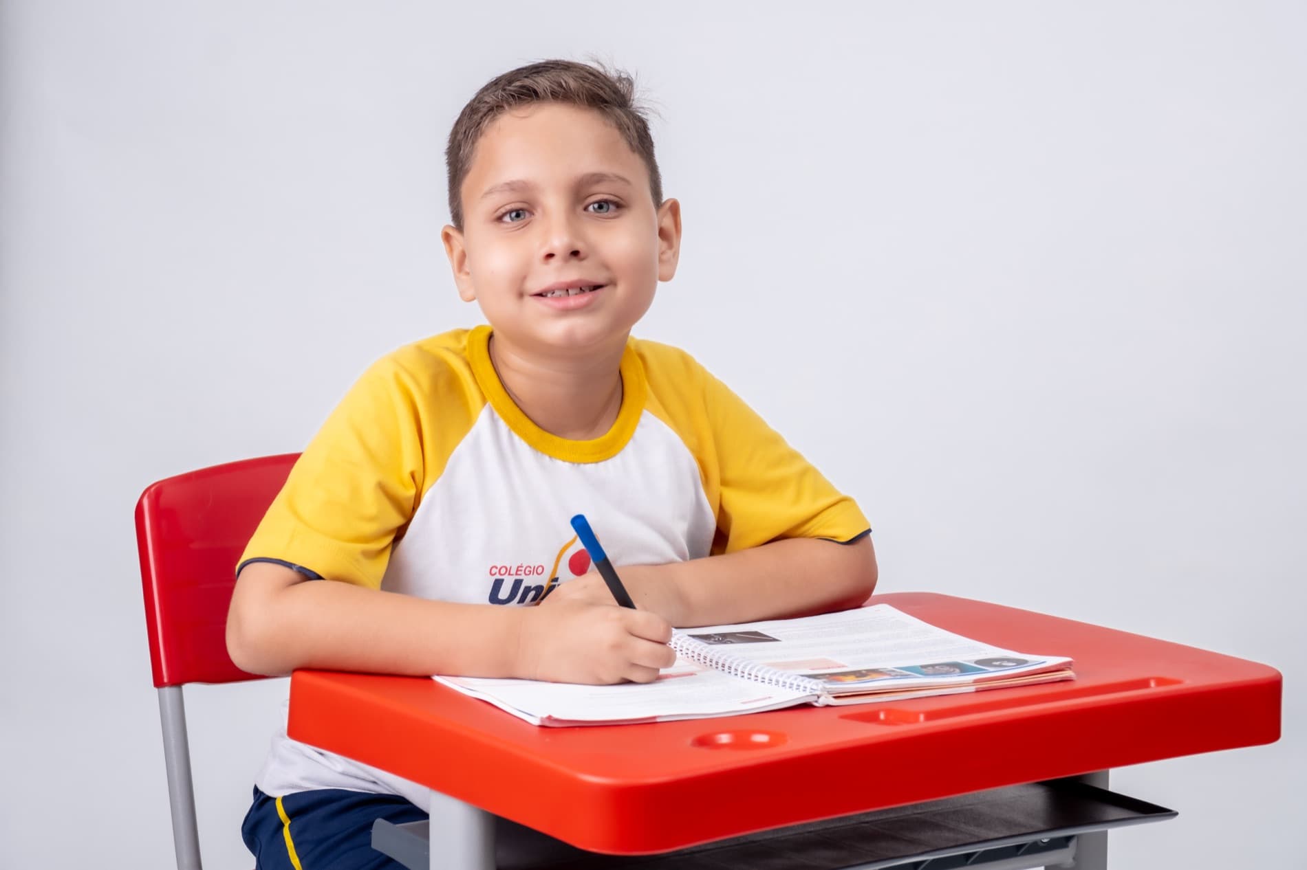 Aluno do Fundamental I do Colégio Universo escrevendo no caderno em sala