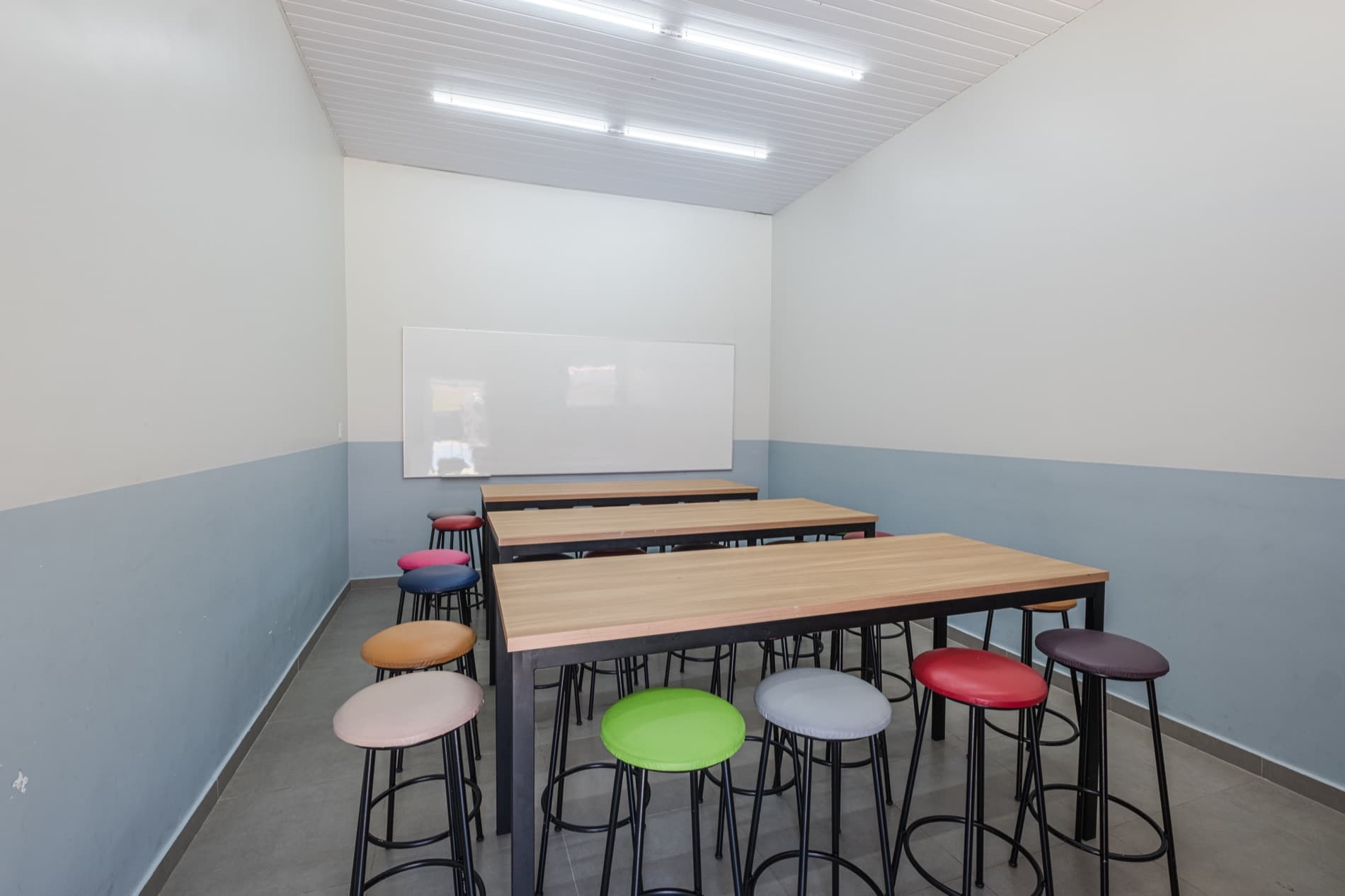 Espaço maker do Colégio Universo, com bancadas colaborativas e banquetas