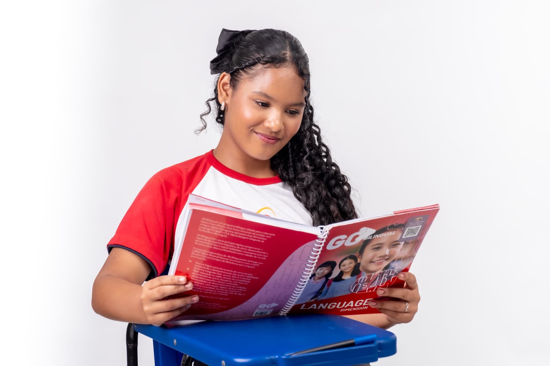Aluna do Colégio Universo lendo o livro de inglês do programa bilíngue